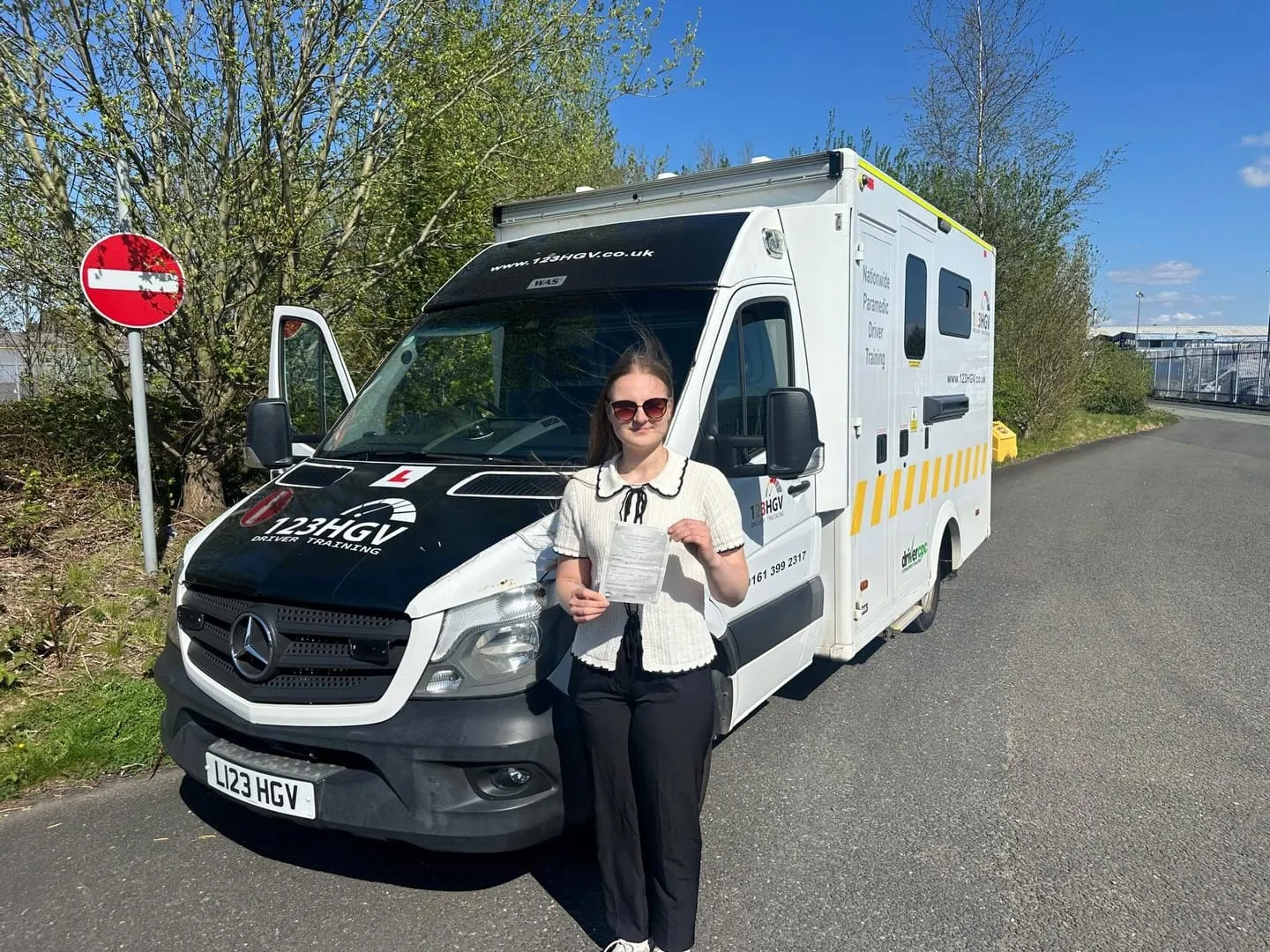 C1 learner pass photograph beside an ambulance training vehicle in Wigan